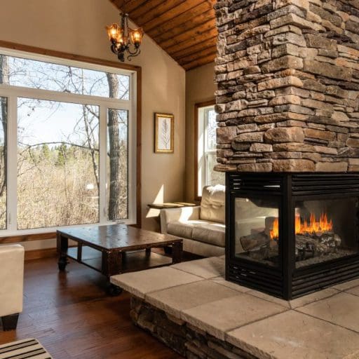 Inside a Clear Lake Cabin in winter with a cozy couch and warm fire in the fireplace.