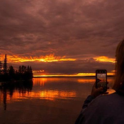 Someone taking a picture of the Clear Lake sunset on their phone.