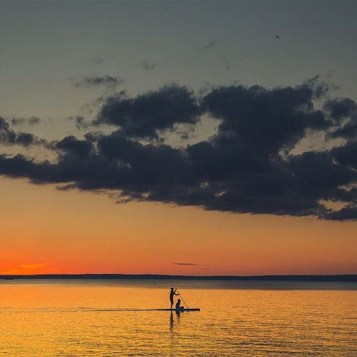 People paddling on Clear Lake at sunset.